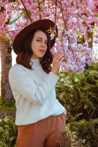 Retrato de una hermosa mujer caucásica con cerezos en flor de sakura