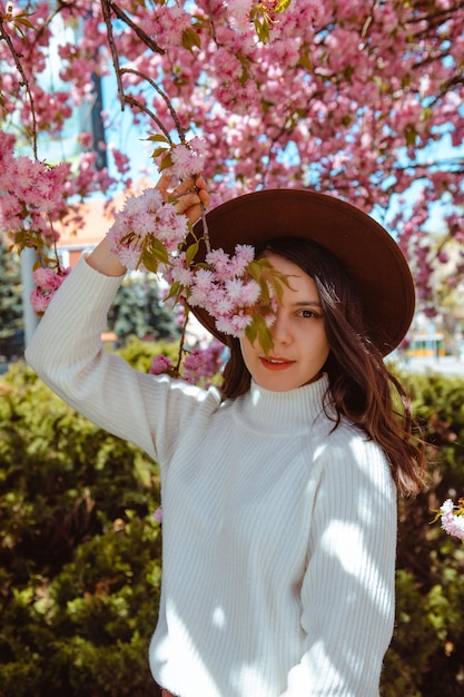 Retrato de una hermosa mujer caucásica con cerezos en flor de sakura