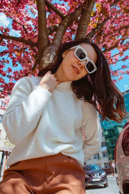 Retrato de una hermosa mujer caucásica con cerezos en flor de sakura