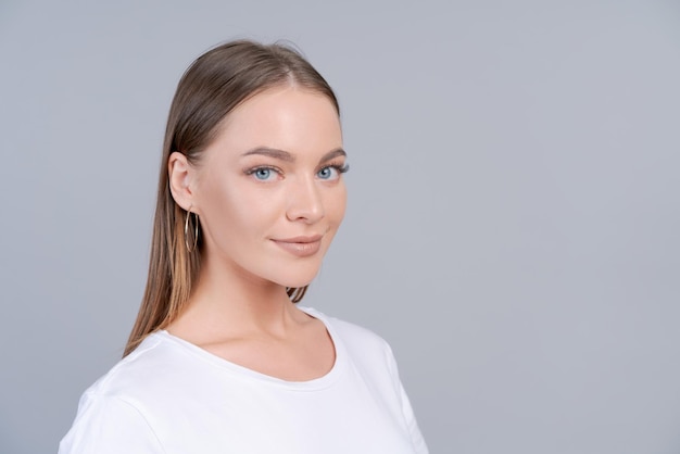 Retrato de una hermosa mujer caucásica emocional sonriendo mirando a la cámara