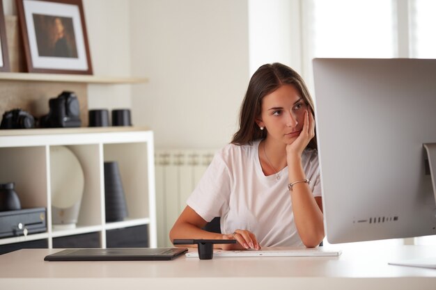 Retrato de hermosa mujer caucásica de fotógrafo trabajando en la oficina en casa