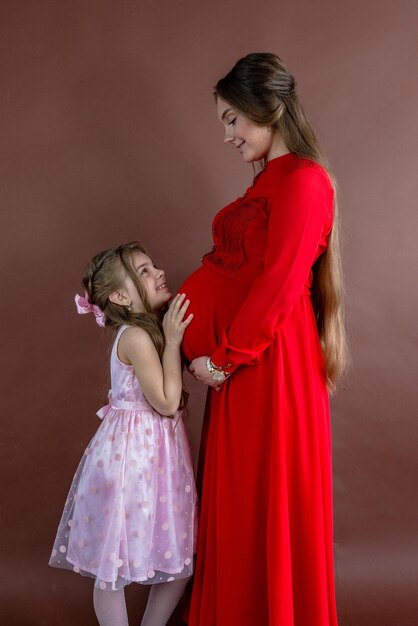 Foto retrato de hermosa mujer embarazada y su linda hija en estudio