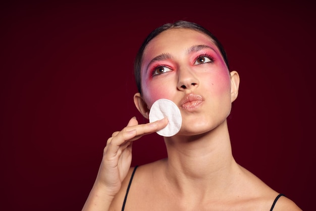 Retrato de hermosa mujer joven almohadillas de algodón cuero limpio maquillaje brillante posando vista recortada inalterada