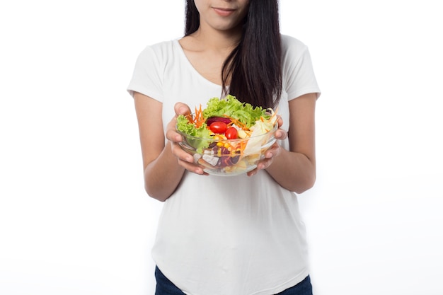 Retrato de hermosa mujer joven asiática comiendo ensalada de verduras aislado en blanco.