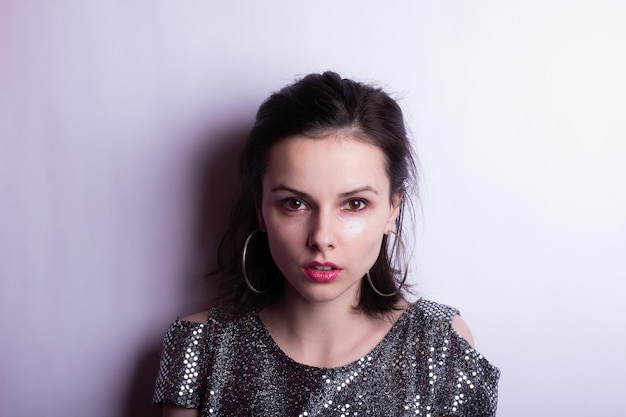 Foto retrato de una hermosa mujer joven en una blusa de mejor aspecto con maquillaje en la cara