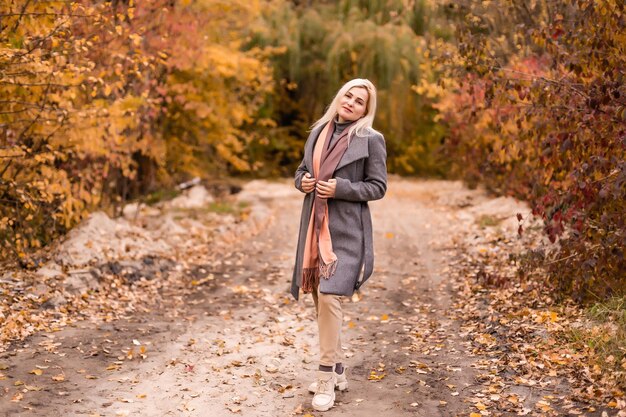 Retrato de hermosa mujer joven caminando al aire libre en otoño