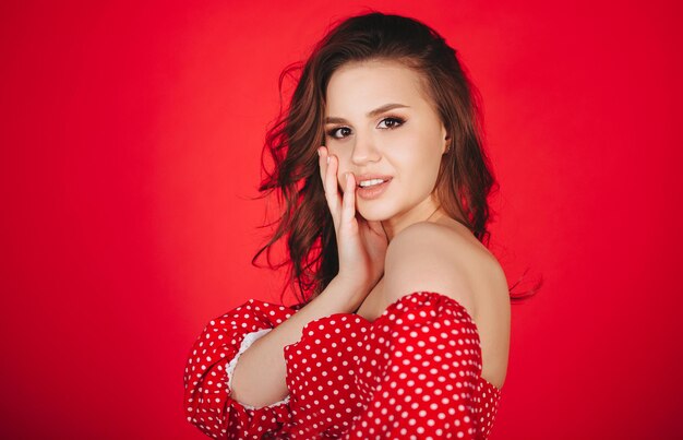 Foto retrato de una hermosa mujer joven contra un fondo rojo