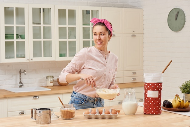 Retrato de hermosa mujer joven desayunando en la cocina