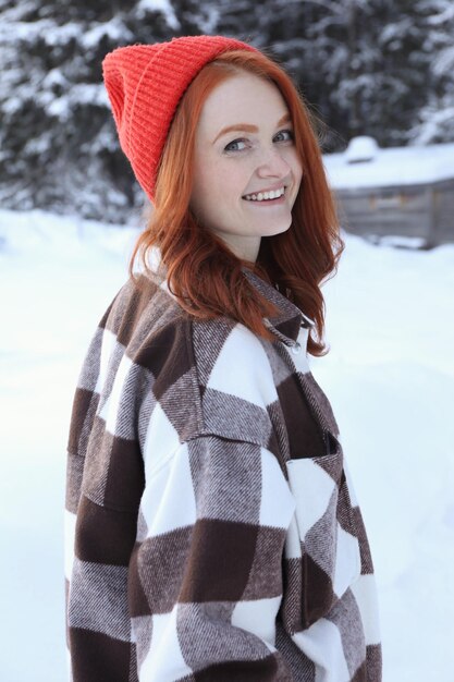 Foto retrato de una hermosa mujer joven en un día nevado al aire libre vacaciones de invierno