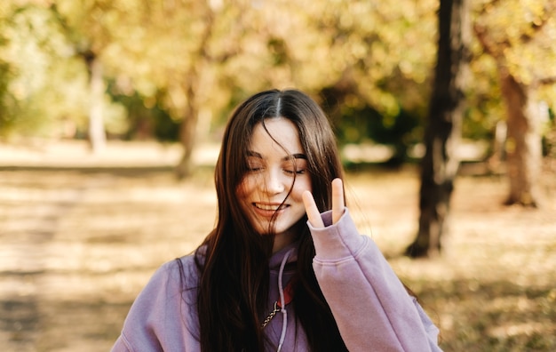 Retrato de hermosa mujer joven divirtiéndose en el parque de otoño.