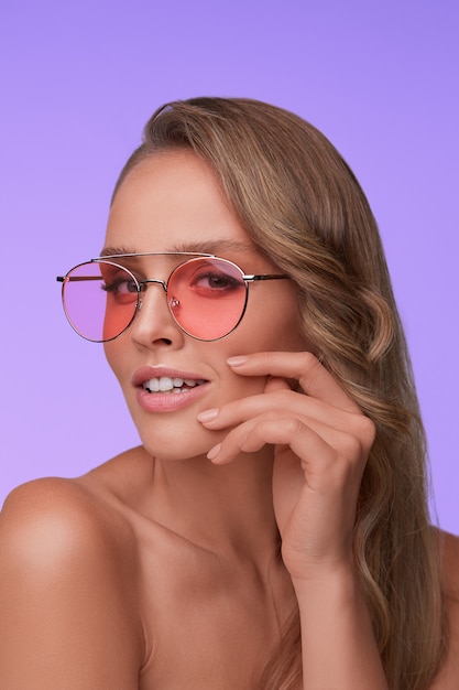 Foto retrato de hermosa mujer joven con gafas de sol rojos. modelo de moda sensual