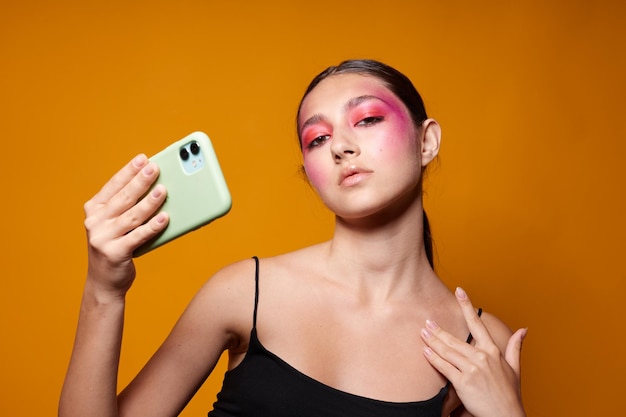 Retrato de hermosa mujer joven maquillaje de cara rosa posando mirada atractiva selfie vista recortada inalterada