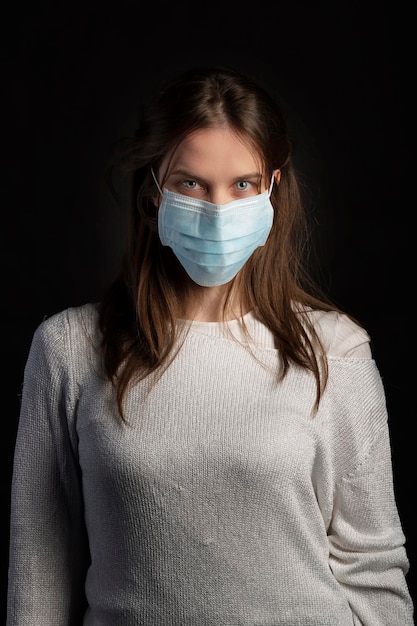 Foto retrato de una hermosa mujer joven con una máscara quirúrgica