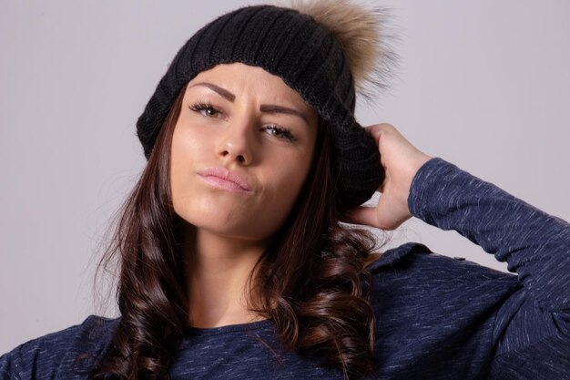 Foto retrato de una hermosa mujer joven de pie contra un fondo gris