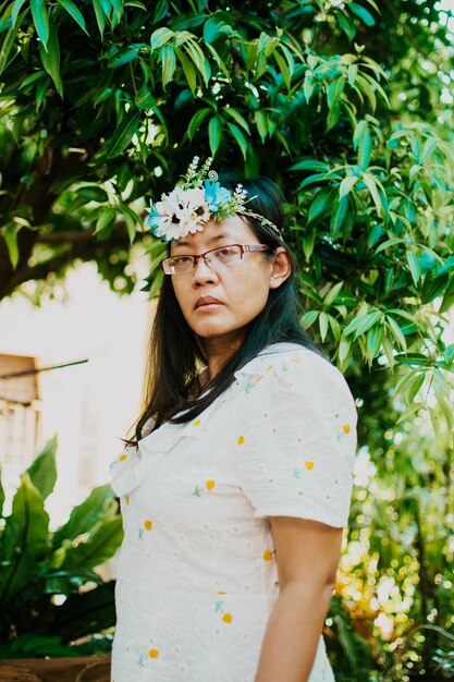 Foto retrato de una hermosa mujer joven de pie contra las plantas