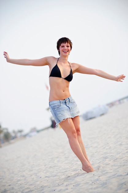 Retrato de hermosa mujer joven en la playa. Modelo femenino en bikini divirtiéndose al aire libre.