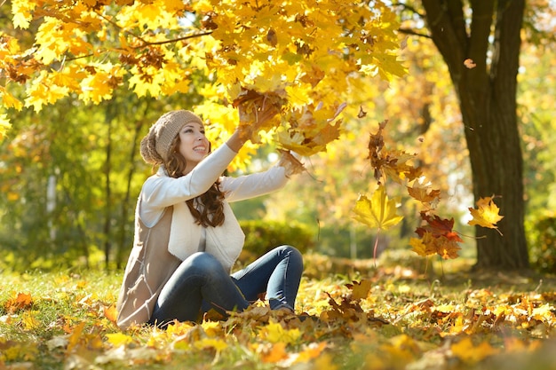 Retrato de una hermosa mujer joven posando en el parque de otoño