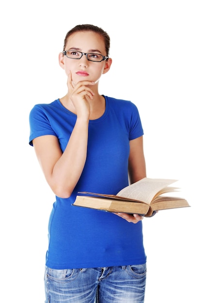 Foto retrato de una hermosa mujer joven sosteniendo un libro mientras piensa contra un fondo blanco
