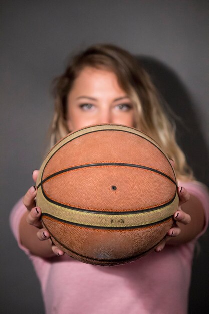 Foto retrato de una hermosa mujer joven sosteniendo una pelota