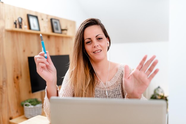 Foto retrato de una hermosa mujer joven usando una computadora portátil en casa