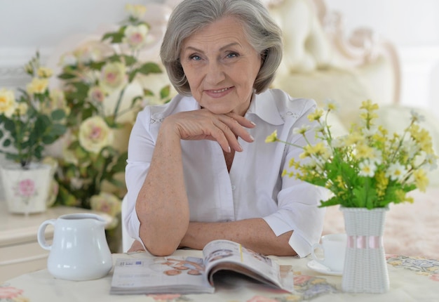 Retrato de una hermosa mujer madura leyendo una revista