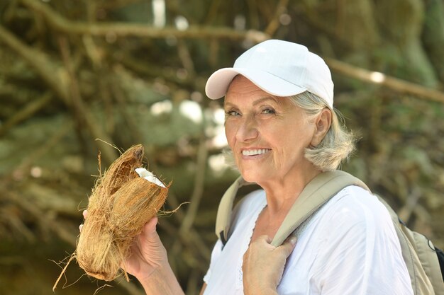 Retrato de una hermosa mujer mayor turista con coco