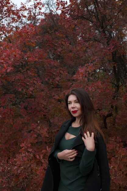 Retrato de una hermosa mujer de mediana edad en un parque de otoño. Hola noviembre. elegante mujer adulta en un hermoso vestido