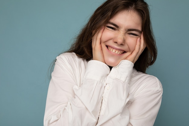 Retrato de hermosa mujer morena joven sonriente linda alegre positiva en camisa blanca casual