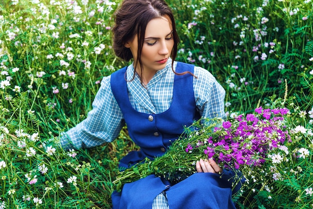 Retrato de una hermosa mujer morena con vestido azul en el campo