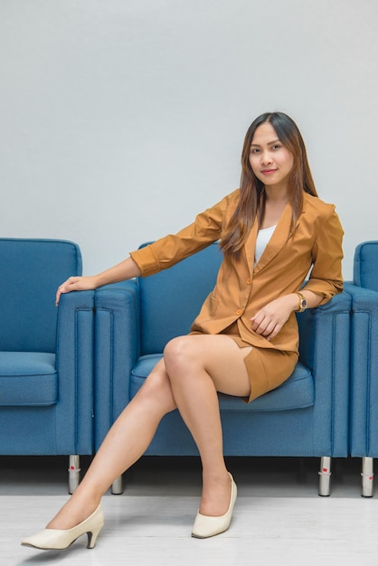 Retrato de una hermosa mujer de negocios asiática que usa un vestido amarillo en una oficina. La gente de Tailandia usa uniformes de damas.