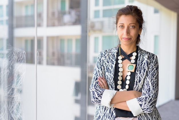 Retrato de hermosa mujer de negocios por la ventana de cristal del edificio de oficinas en el interior