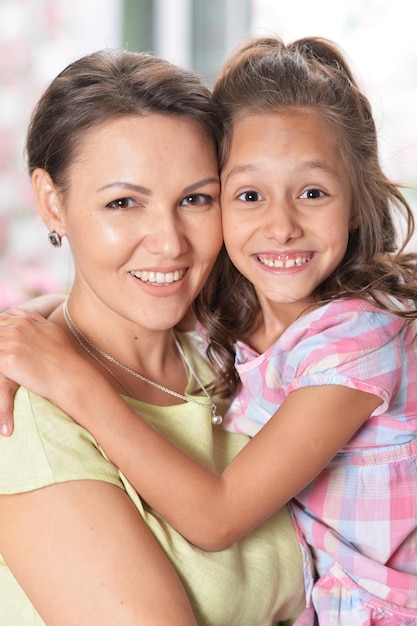 Retrato de una hermosa mujer y una niña abrazándose