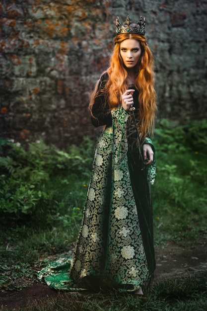 Retrato de una hermosa mujer pelirroja con vestido medieval verde