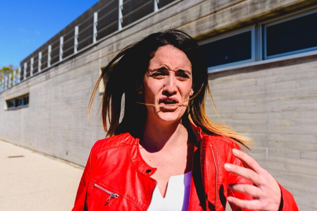 Retrato de una hermosa mujer de pie contra un edificio