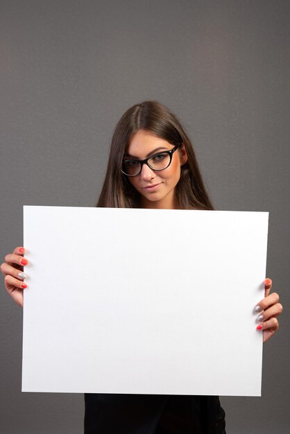 Retrato de una hermosa mujer de pie contra un fondo blanco