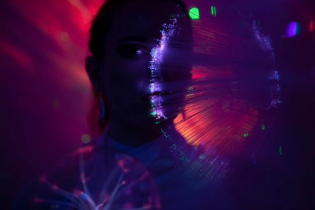 Retrato de una hermosa mujer de pie contra la luz iluminada