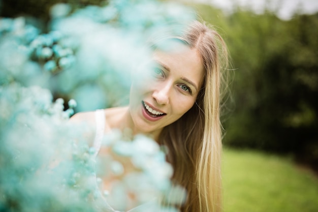 Retrato de hermosa mujer rubia con ramo de flores azules