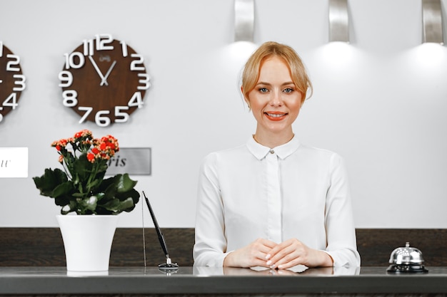 Retrato de hermosa mujer rubia recepcionista de hotel de cerca