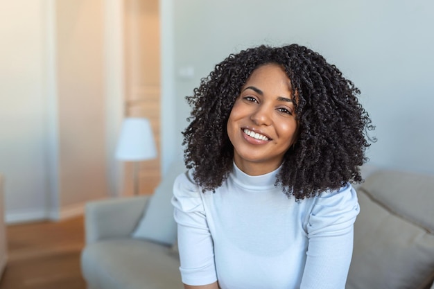 Retrato de una hermosa mujer sonriendo en casa Mujer africana en casual mirando a la cámara con espacio de copia Alegre niña de raza mixta relajándose en casa con una gran risa