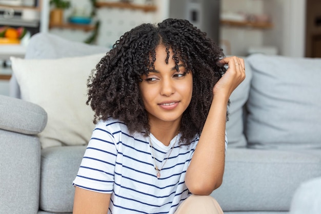 Retrato de una hermosa mujer sonriendo en casa Mujer africana en casual mirando a la cámara con espacio de copia Alegre niña de raza mixta relajándose en casa con una gran risa