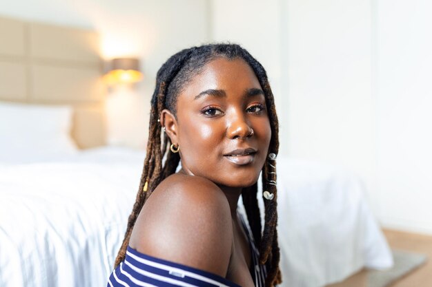 Retrato de una hermosa mujer sonriendo en casa Mujer africana en casual mirando a la cámara con espacio de copia Alegre niña de raza mixta relajándose en casa