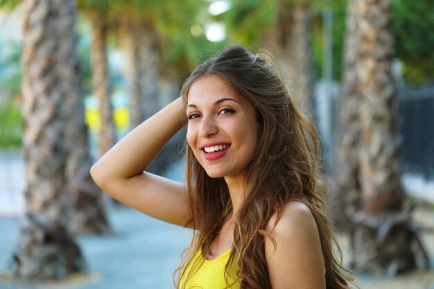 Foto retrato de una hermosa mujer sonriendo mientras está de pie en la playa