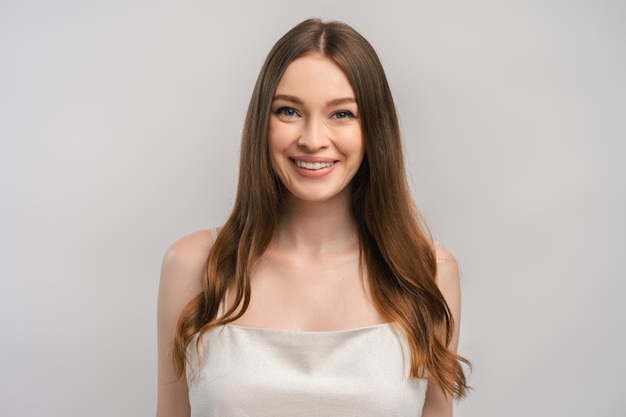 Retrato de una hermosa mujer sonriente con camiseta mirando a la cámara