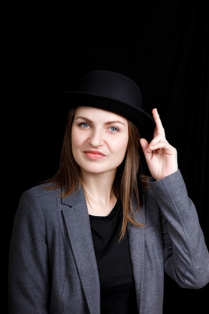 Foto retrato de una hermosa mujer vestida con chaqueta y sombrero