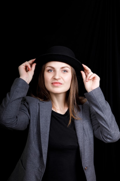 Retrato de una hermosa mujer vestida con chaqueta y sombrero