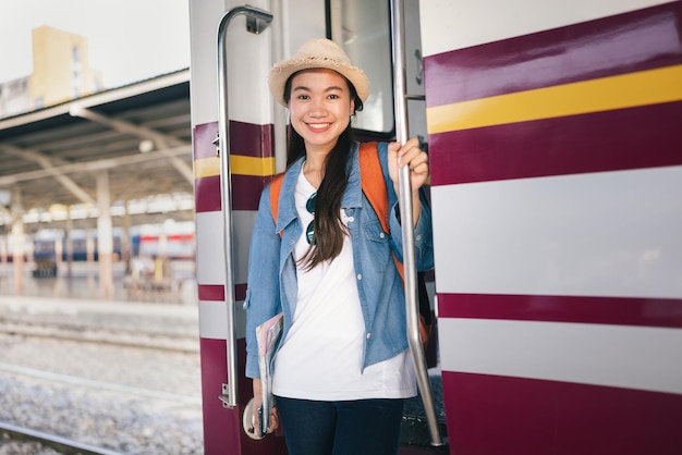 Retrato hermosa mujer viajero turista con mochila en la estación de tren