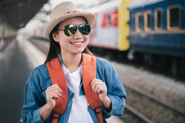 Retrato hermosa mujer viajero turista con mochila en la estación de tren