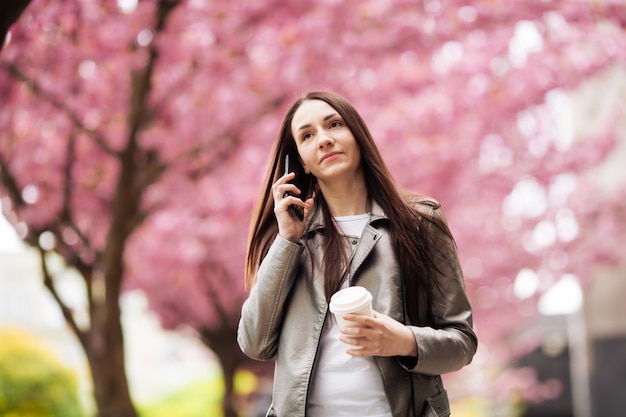 Retrato de una hermosa niña en un árbol de sakura.