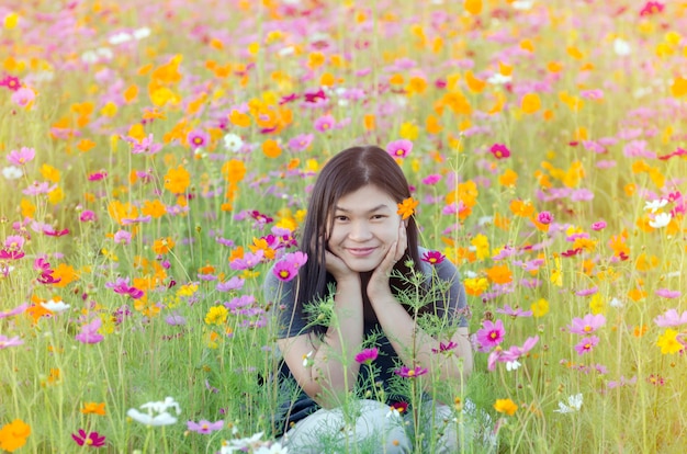 Retrato de hermosa niña asiática en campos de flores de cosmos