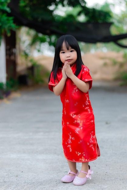 Retrato hermosa niña asiática en vestido CheongsamGente de TailandiaFeliz concepto de año nuevo chinoFeliz niña asiática en vestido tradicional chino